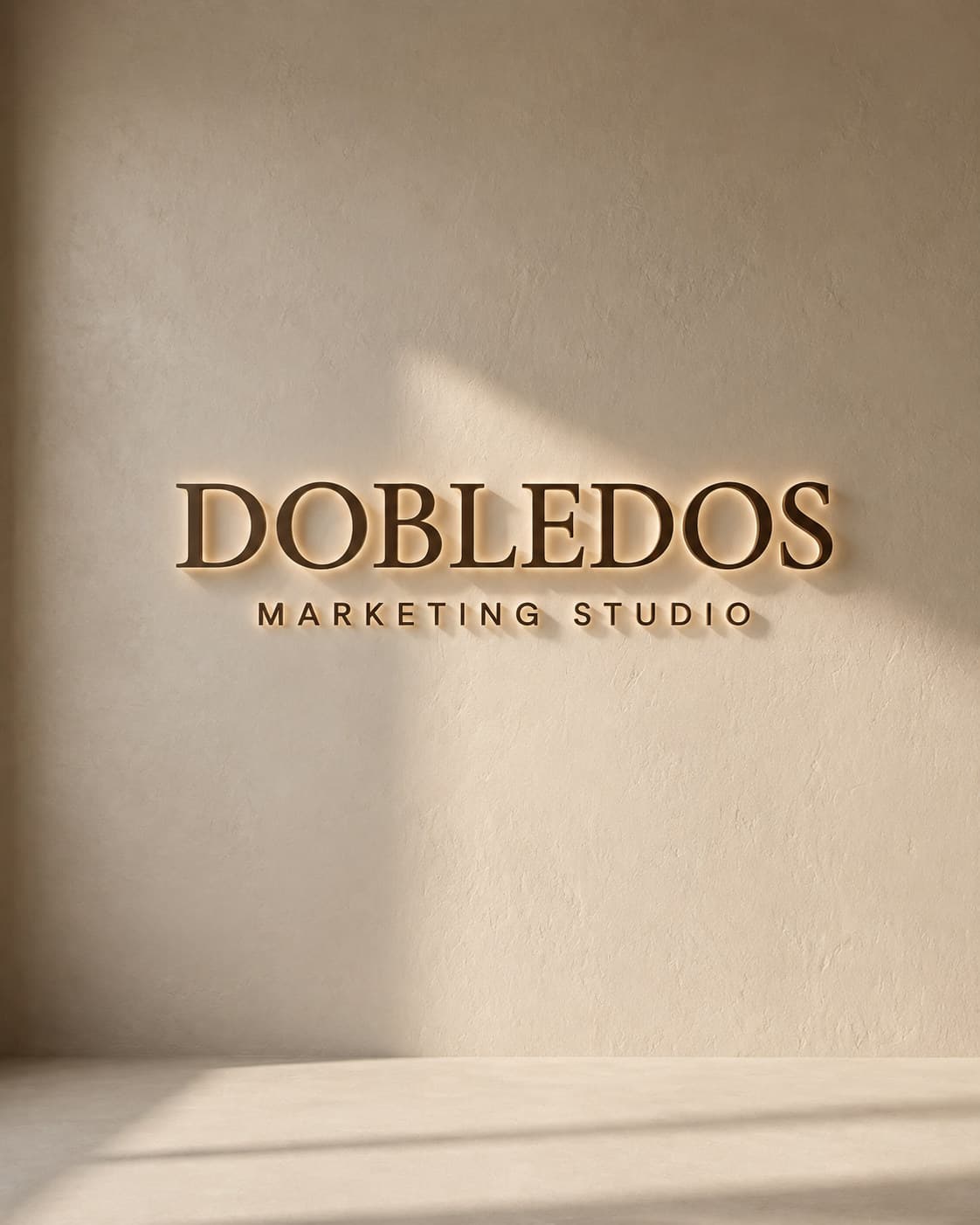 Letras retroiluminadas de Dobledos Marketing Studio en una pared de estuco con luz de ventana